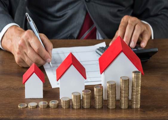 Simulación de la firma de una hipoteca con casas y monedas delante